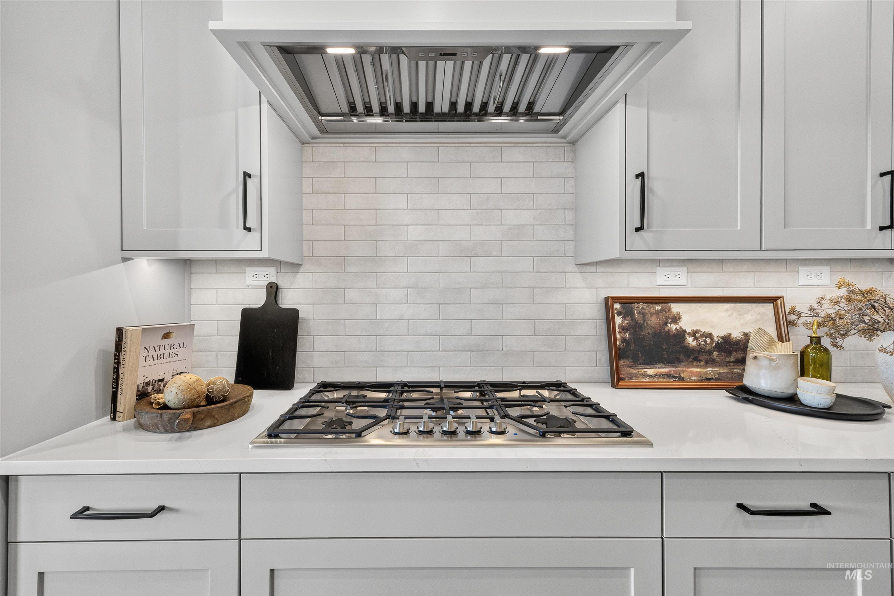 Stainless steel gas range and hood with subway tile backsplash