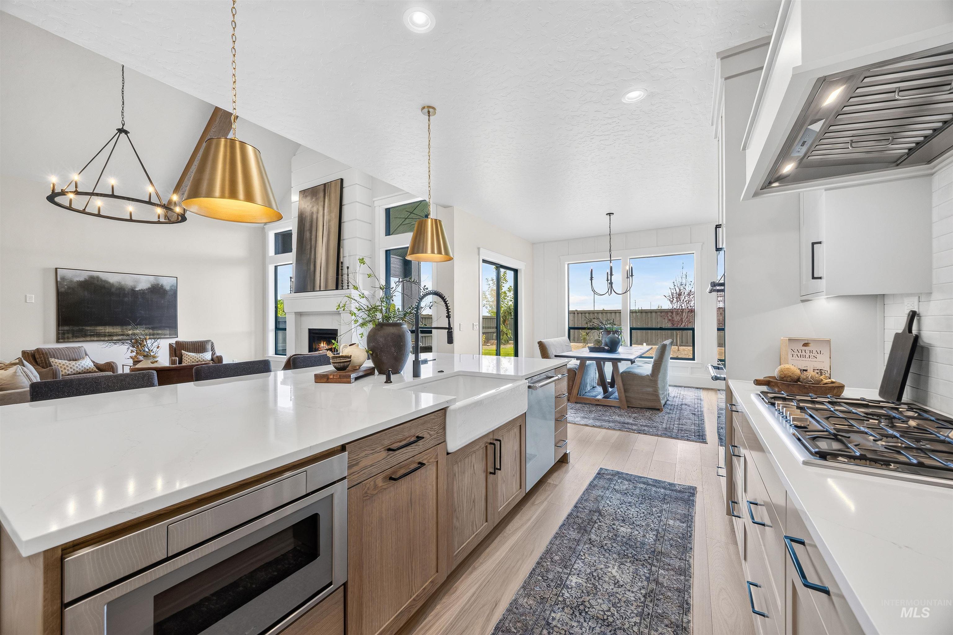 Spacious kitchen island featuring a white countertop, farm sink, and built-in microwave drawer