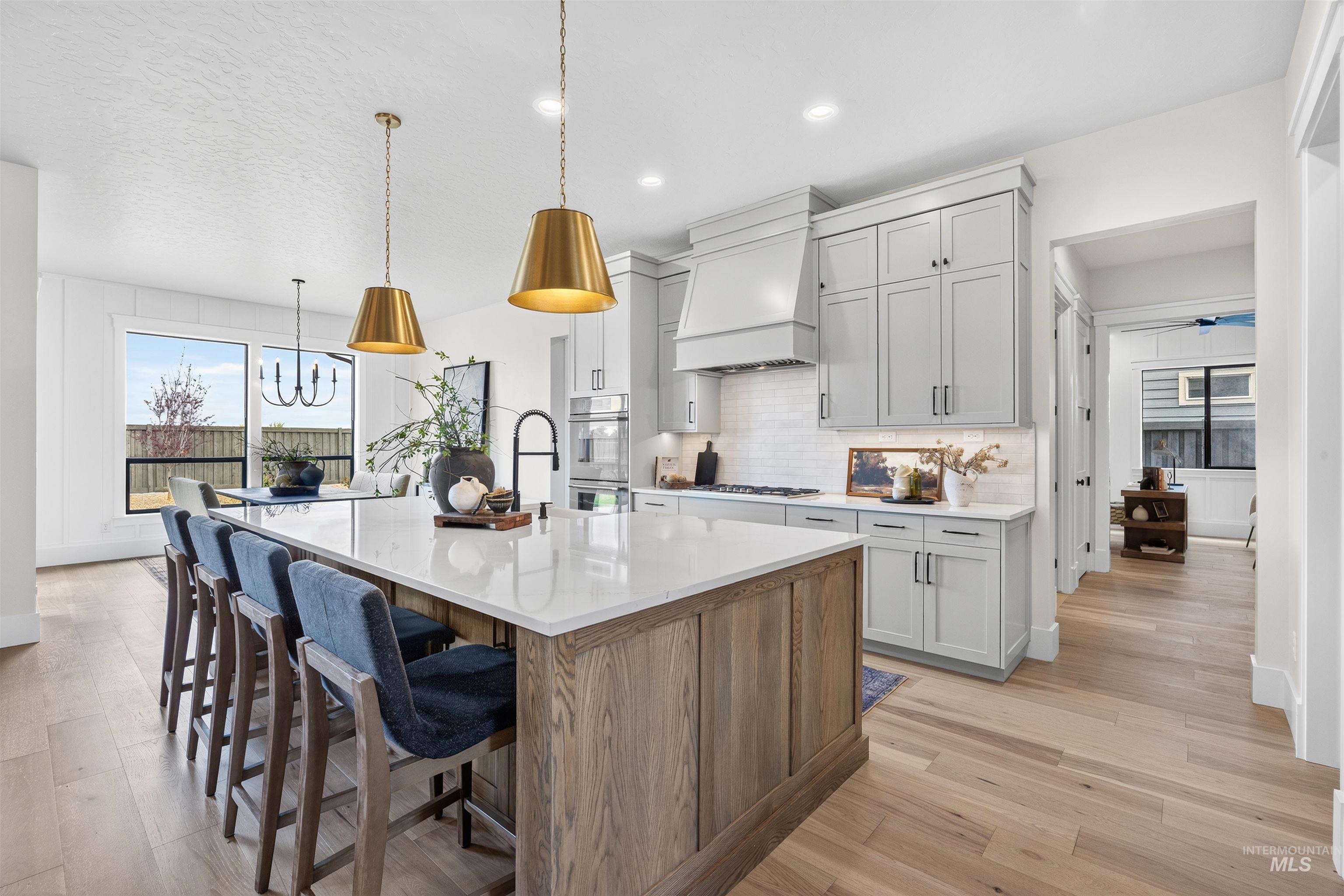 Kitchen featuring an expansive island with a light-toned wood-finish base and a white countertop