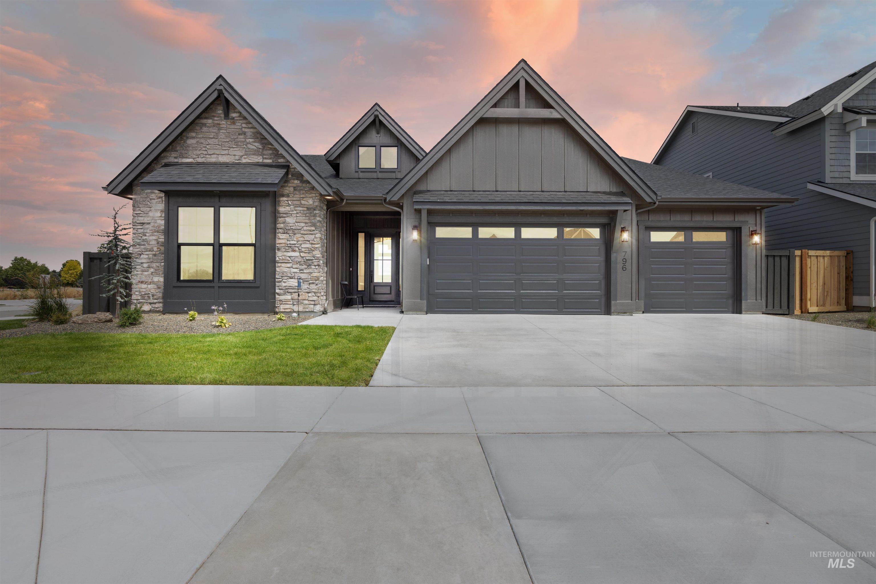 Craftsman-style exterior featuring stone and board-and-batten siding, a multi-car garage, and an inviting front entry