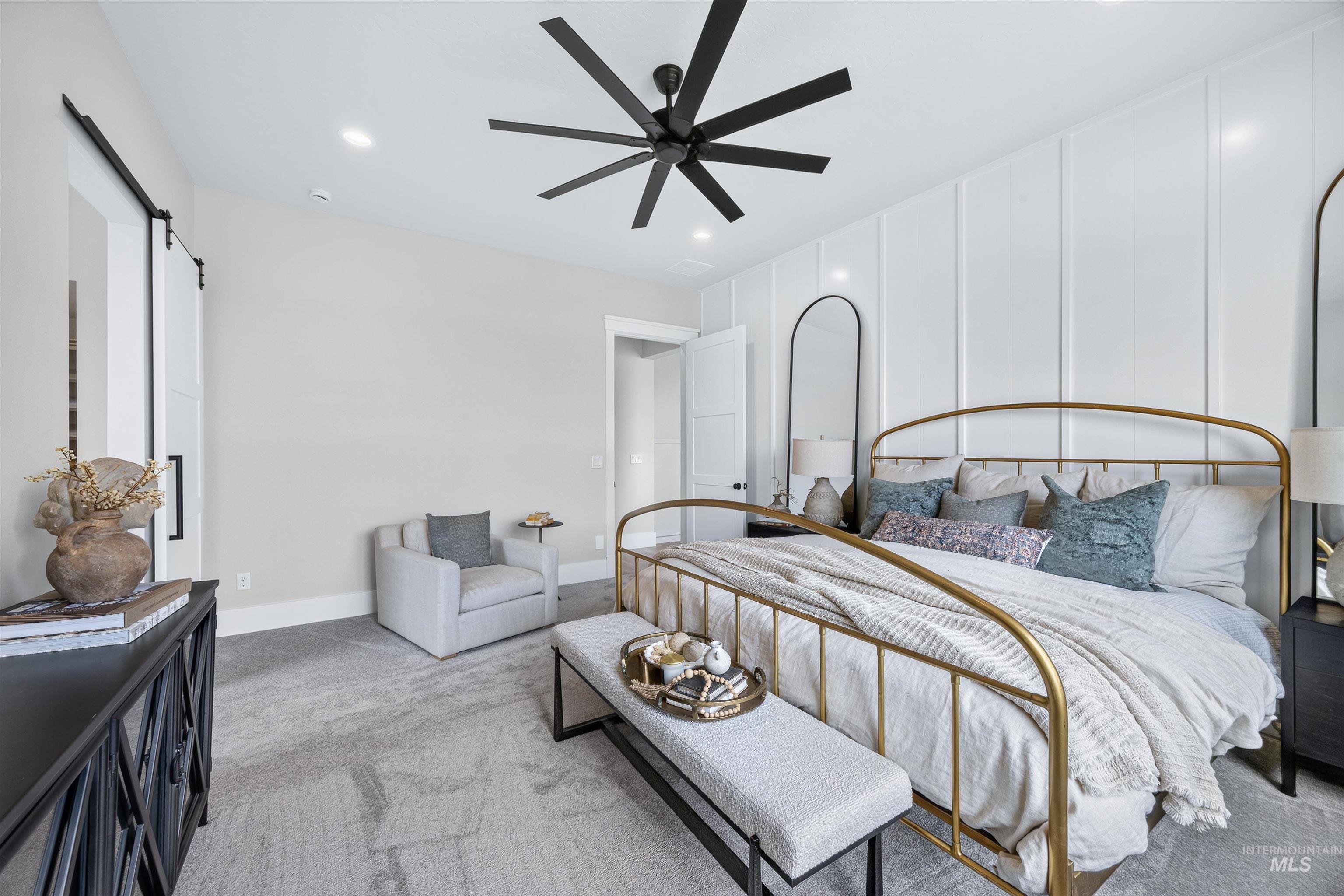 Spacious room featuring a white paneled accent wall and a barn door with black hardware