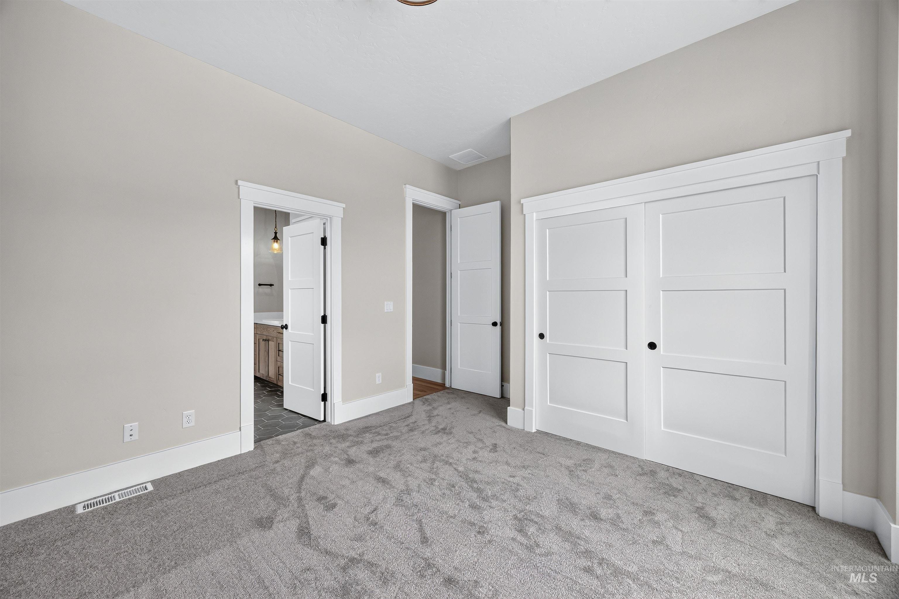 Neutral tone walls complement the gray carpeting