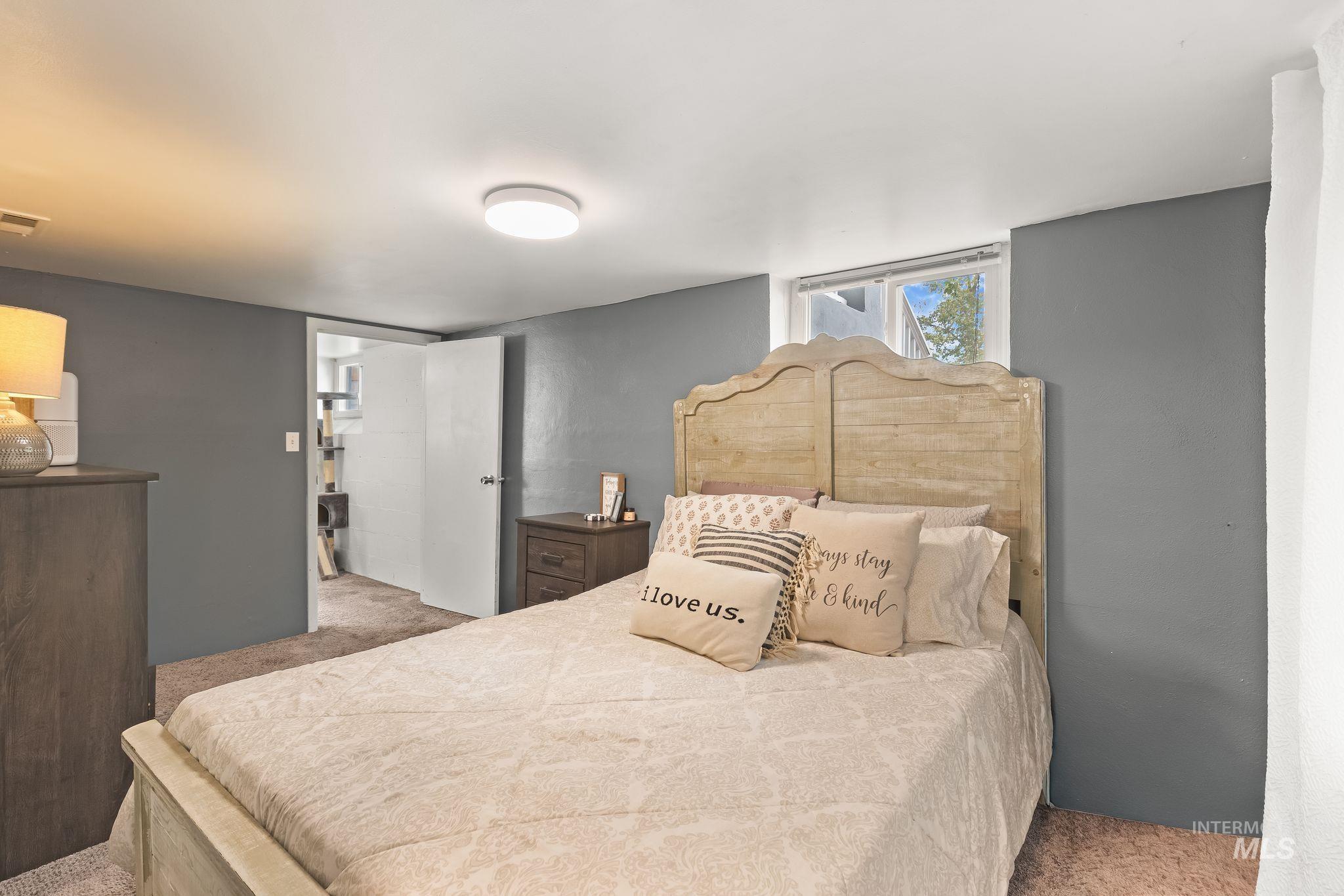 Room featuring a light wood-finish headboard, window, and recessed lighting