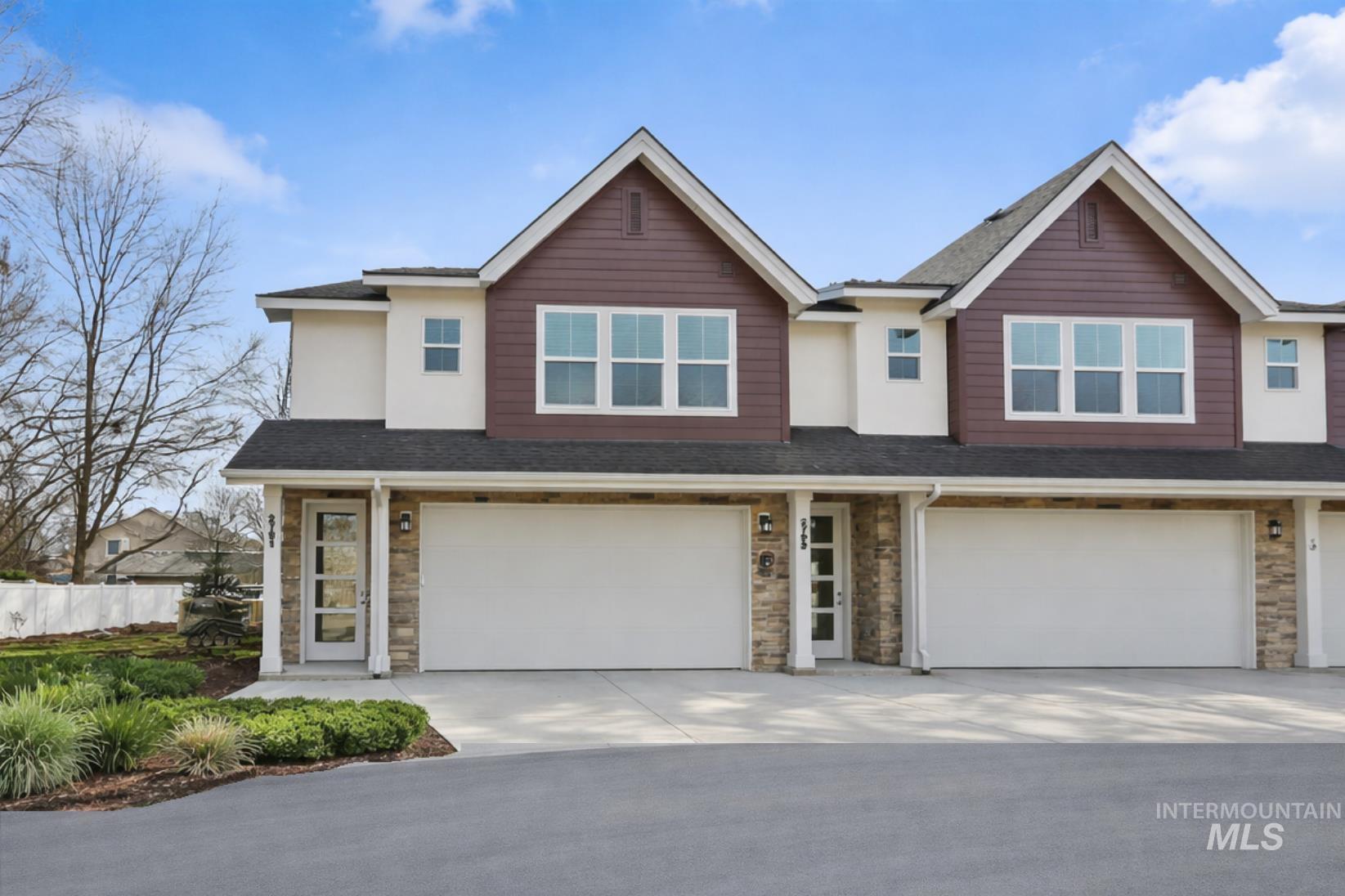 View of front of property featuring stone siding, roof with shingles, and an attached garage
