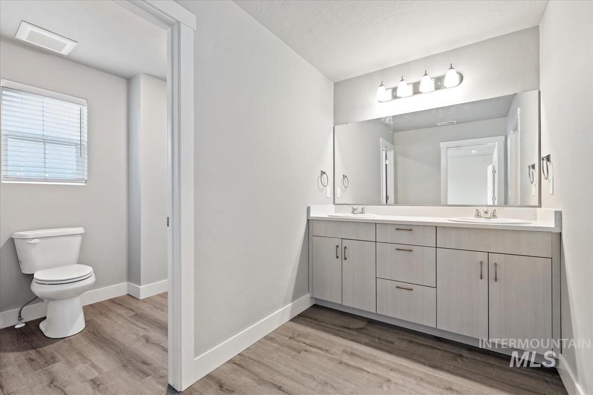 Full bathroom featuring double vanity and light wood-style floors
