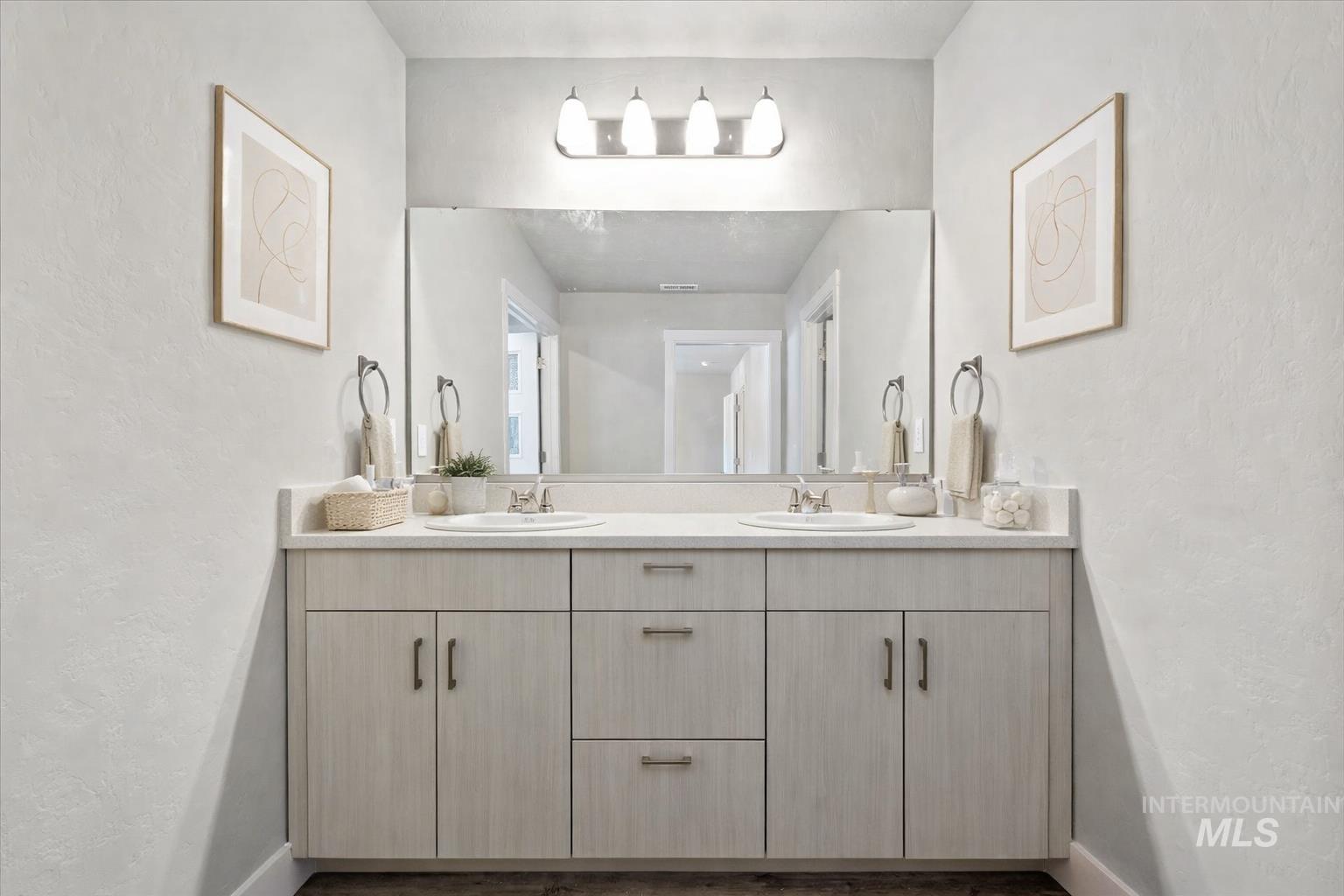 Full bath featuring a textured wall and double vanity