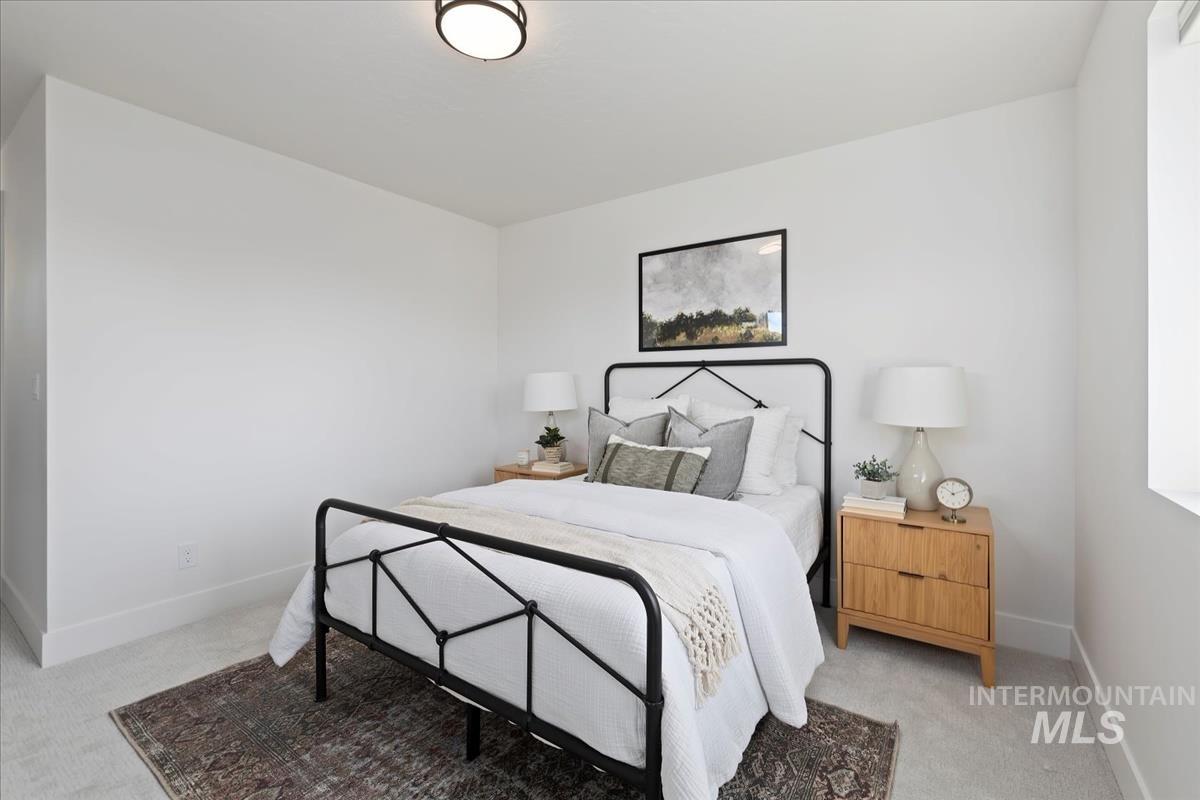 Bedroom featuring light colored carpet and baseboards