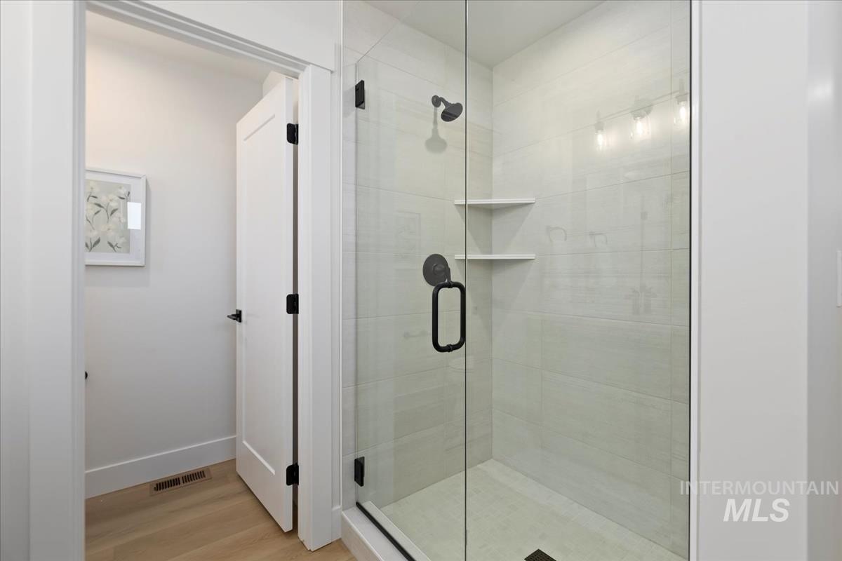 Bathroom featuring a stall shower and wood finished floors