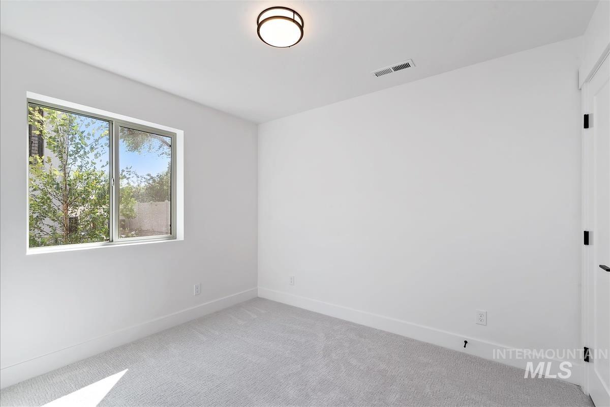 Main level bed with carpet flooring and baseboards