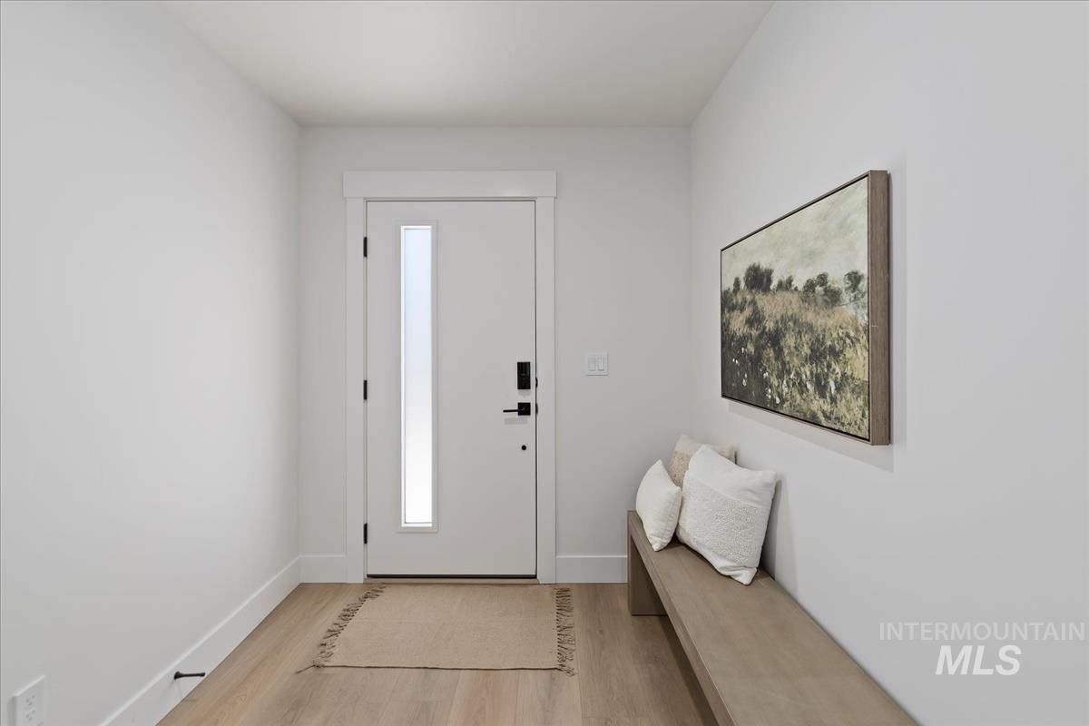 Entryway with light wood-style flooring and baseboards