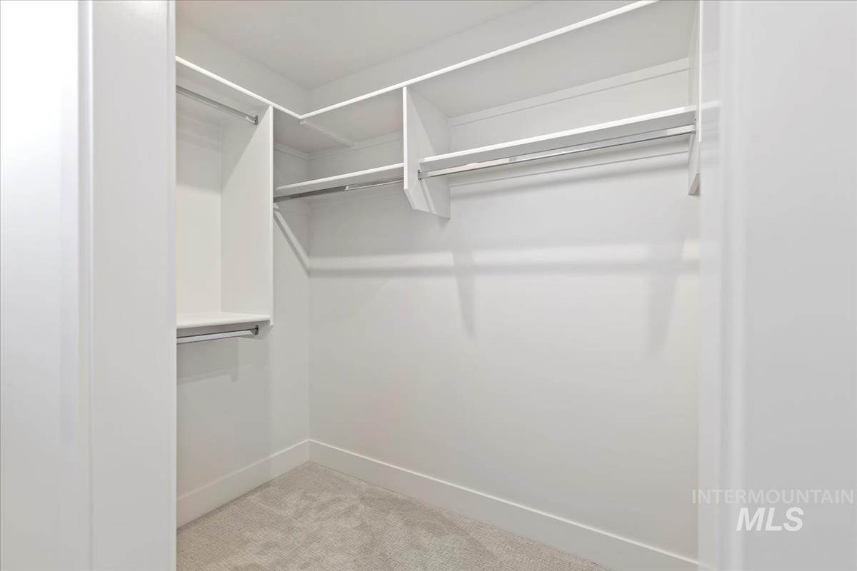 Spacious closet with light carpet
