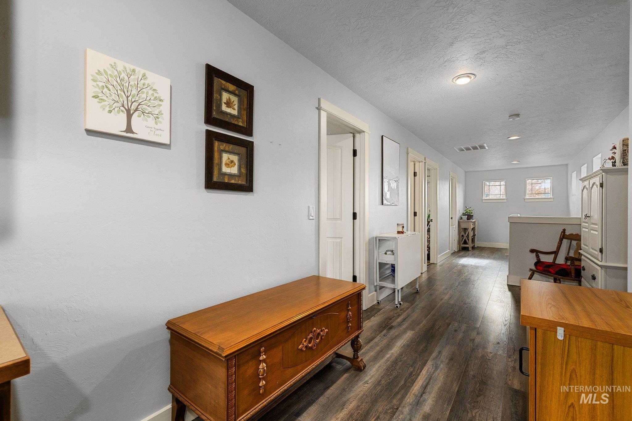 Hallway featuring dark wood-style floors and a textured ceiling