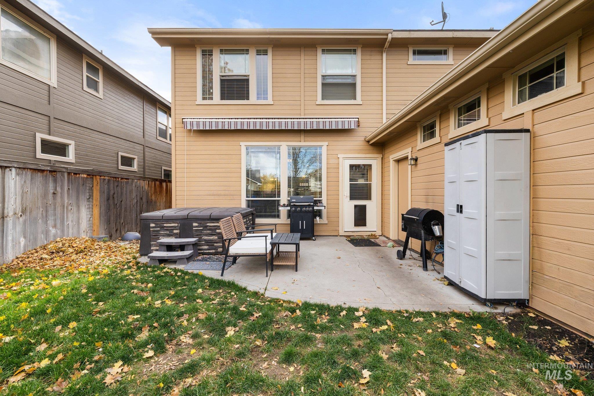 Back of house with a patio area, a hot tub, and a fenced backyard
