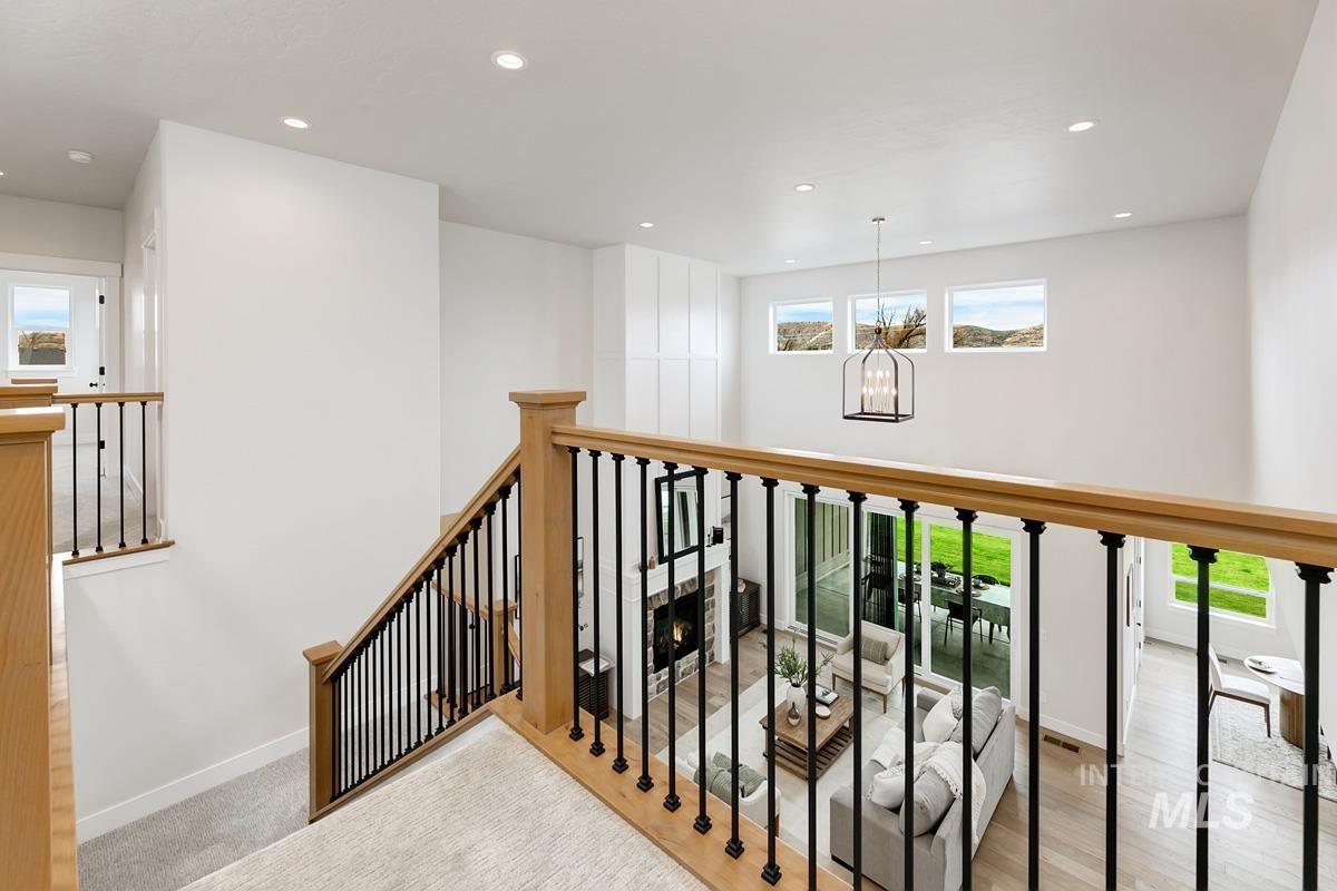 Corridor featuring plenty of natural light, recessed lighting, a chandelier, and an upstairs landing
