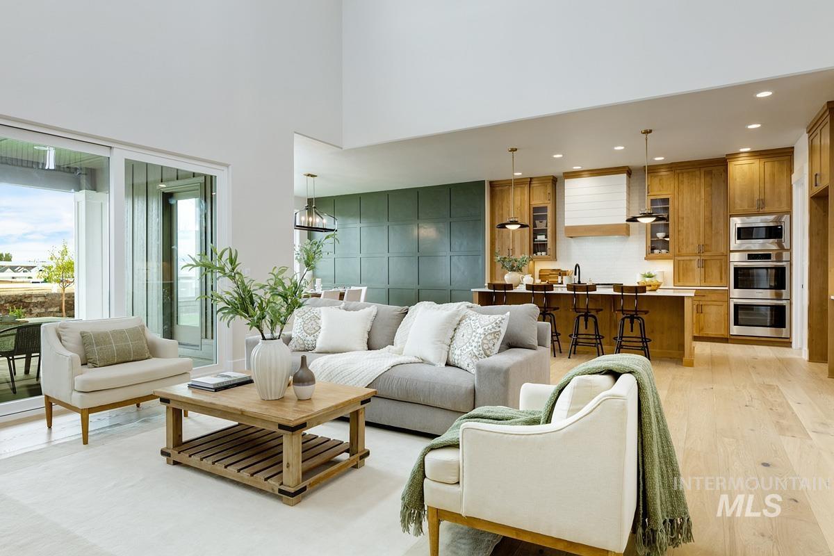 Living room featuring recessed lighting, light wood-type flooring, and a high ceiling