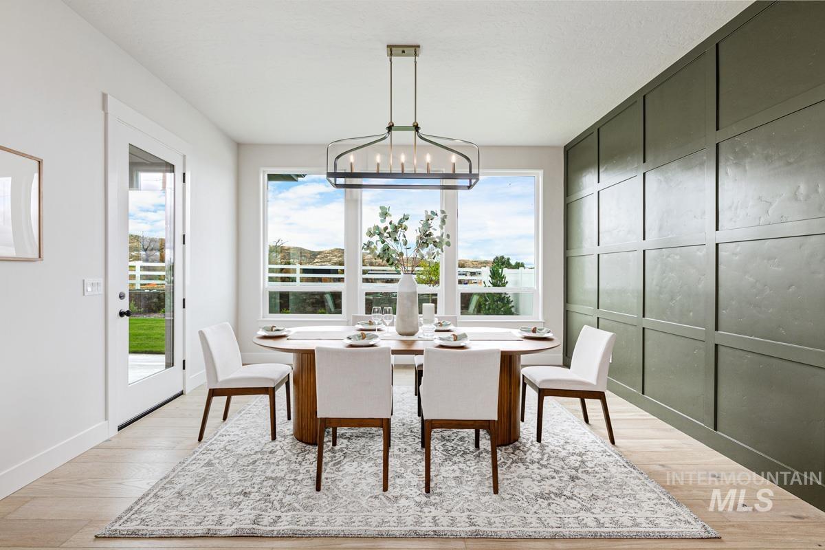 Dining room with a decorative wall, light wood-style flooring, and a chandelier