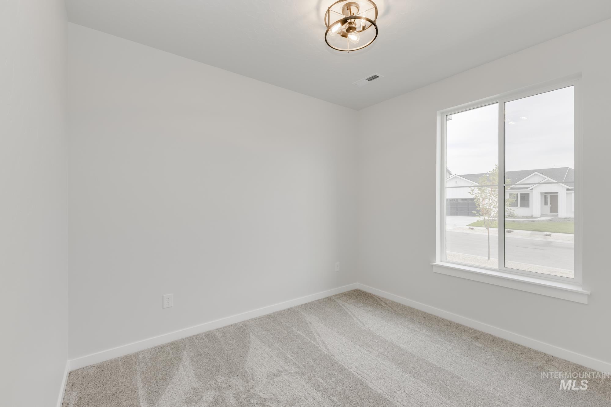 Carpeted empty room featuring baseboards