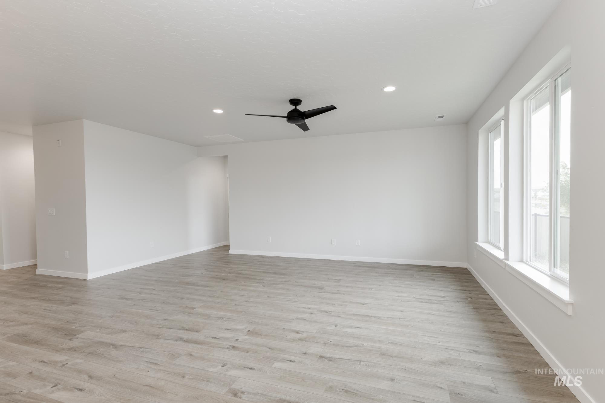 Unfurnished room featuring light wood finished floors, a ceiling fan, and recessed lighting