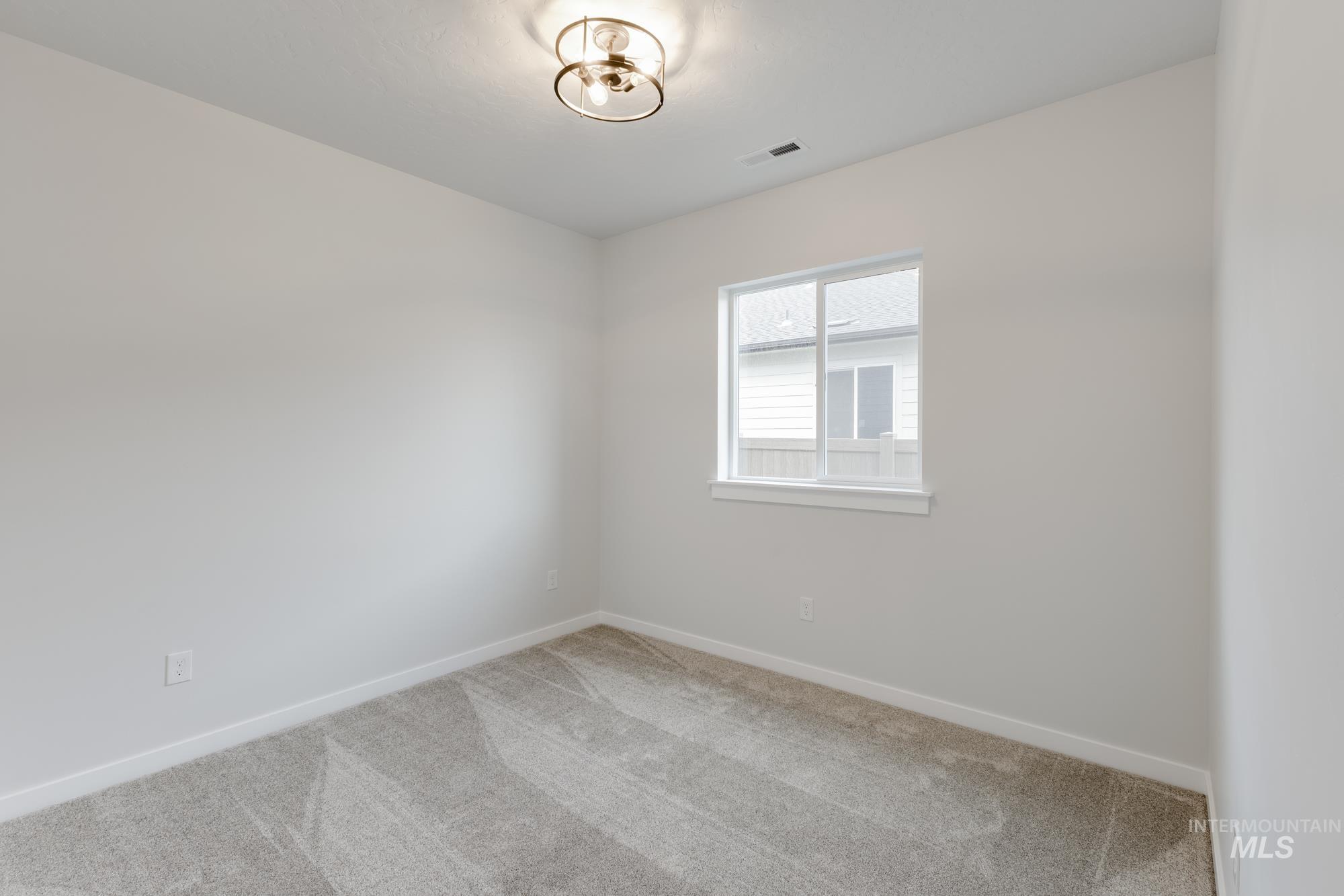 Carpeted empty room featuring baseboards