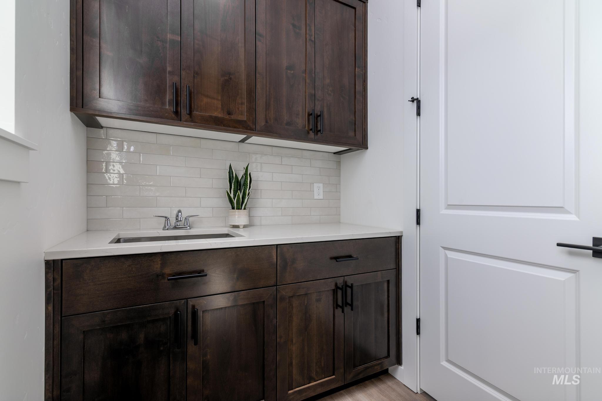 Dark wood-finish cabinetry featuring black hardware and a white countertop
