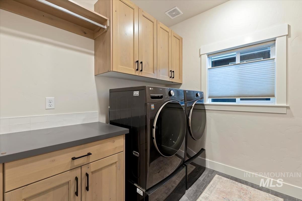 Laundry area featuring washing machine and clothes dryer and cabinet space