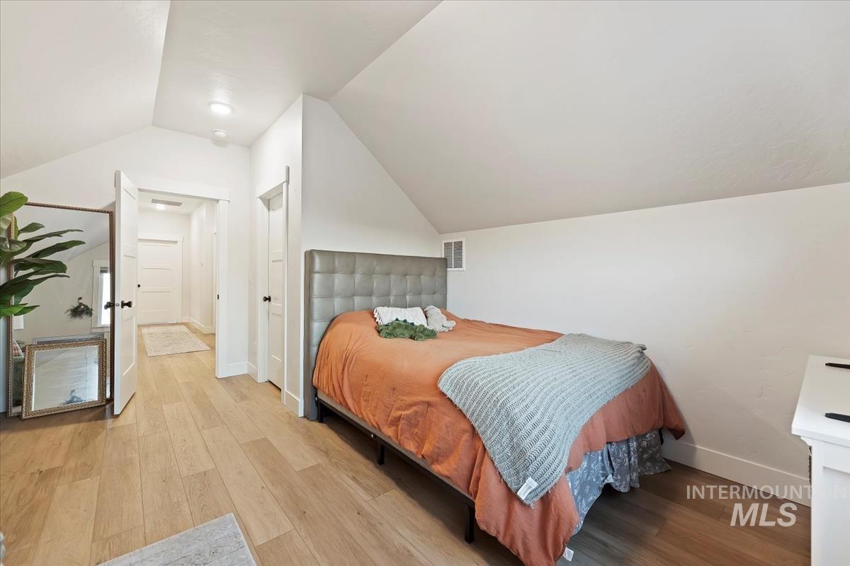 Bedroom featuring vaulted ceiling and light wood finished floors