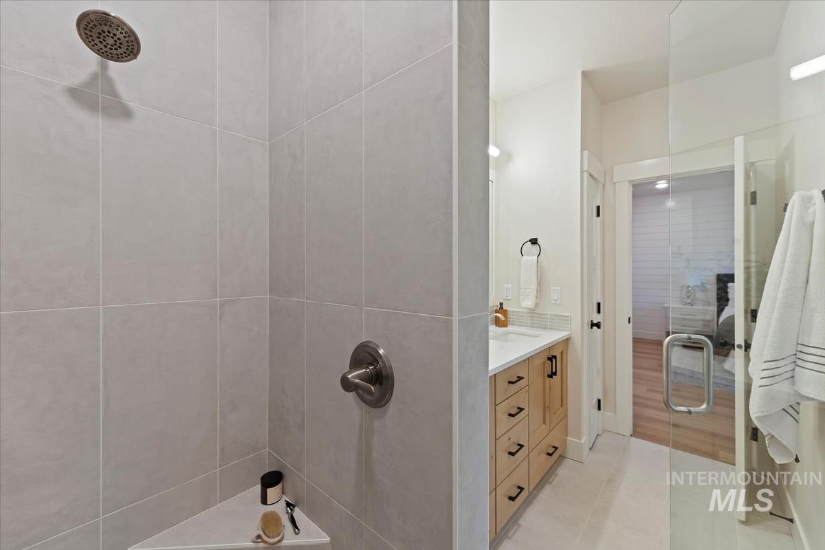 Full bathroom with a stall shower, light tile patterned floors, and vanity