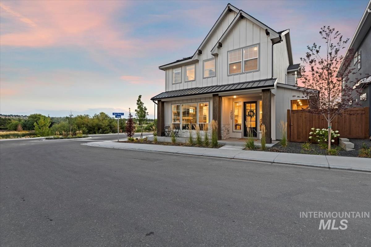 Modern farmhouse style home with board and batten siding, a metal roof, a standing seam roof, and a porch