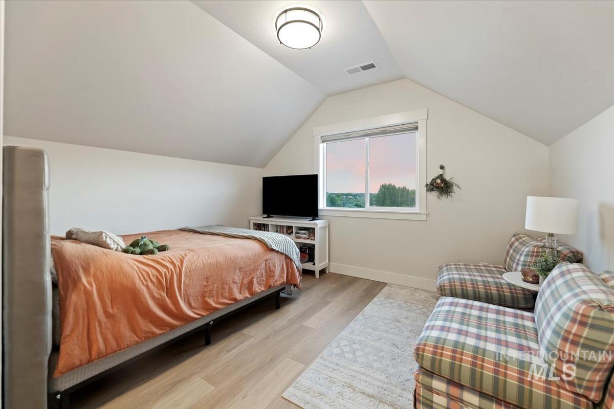 Bedroom featuring vaulted ceiling and light wood-style flooring