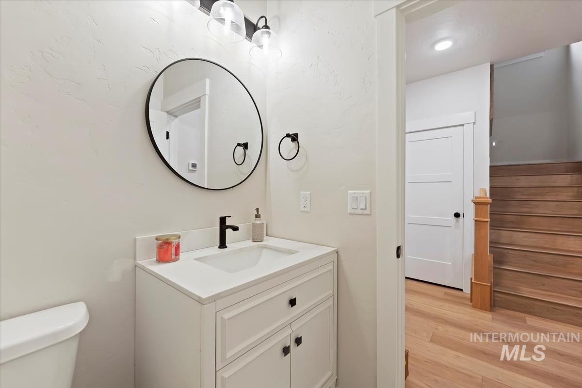 Half bathroom featuring vanity and light wood-style floors