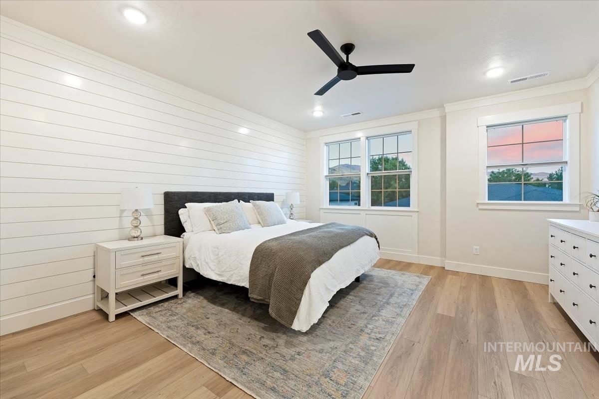 Bedroom with crown molding, light wood finished floors, and ceiling fan