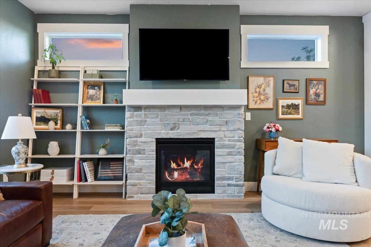 Living room with wood finished floors and a stone fireplace
