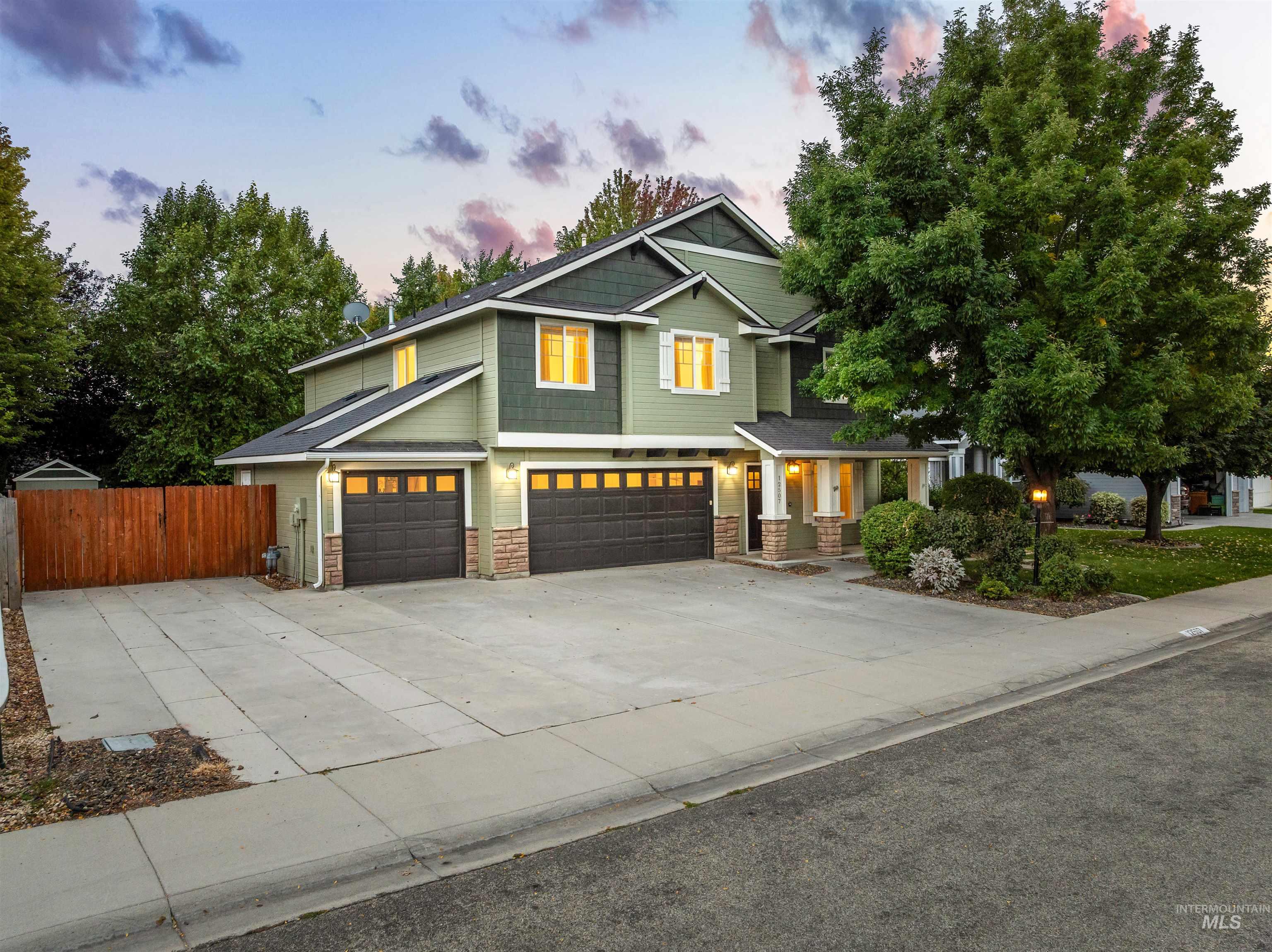 Craftsman-style home featuring driveway, stone siding, and an attached garage