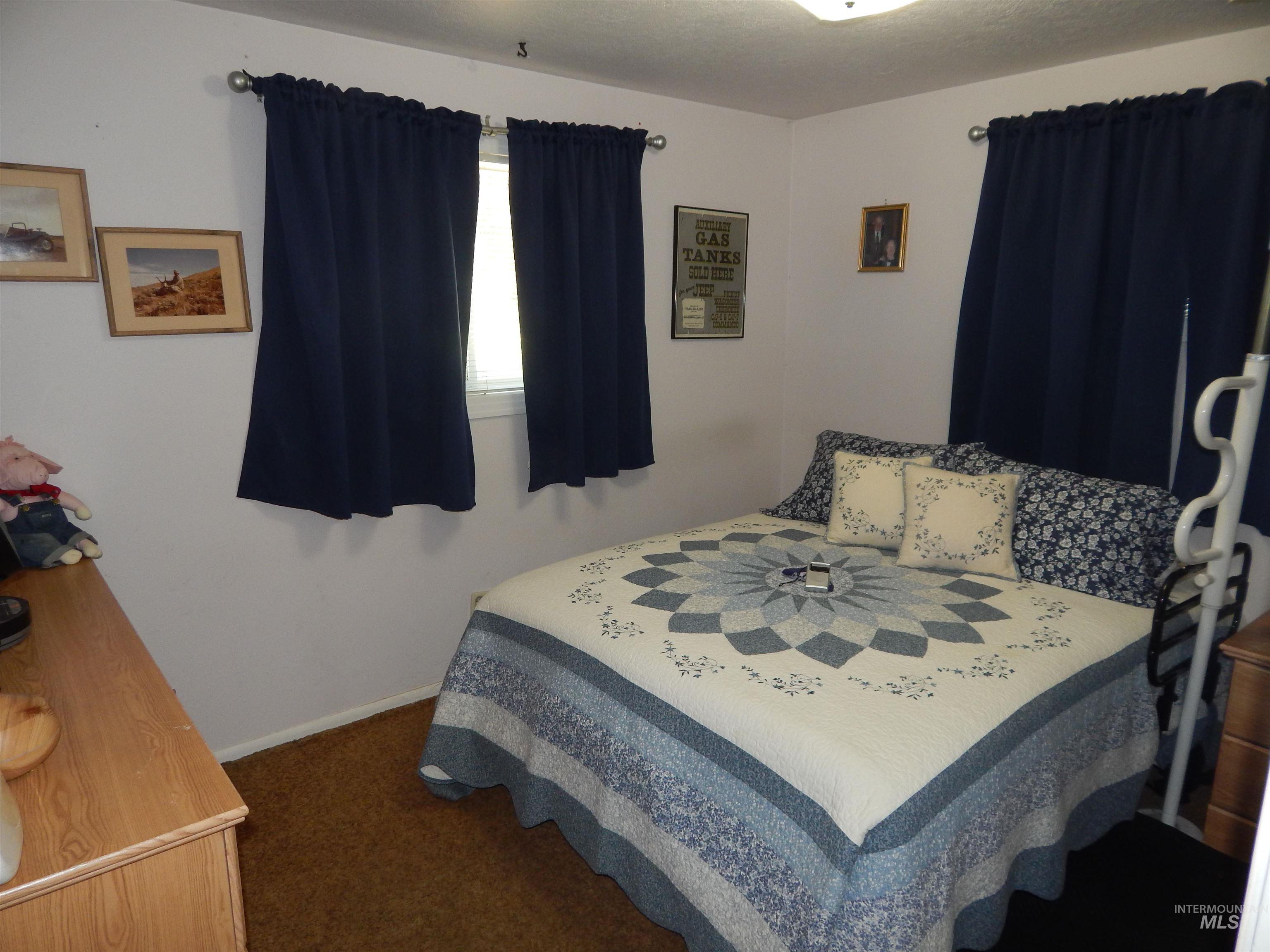 Bedroom with dark colored carpet and a textured ceiling