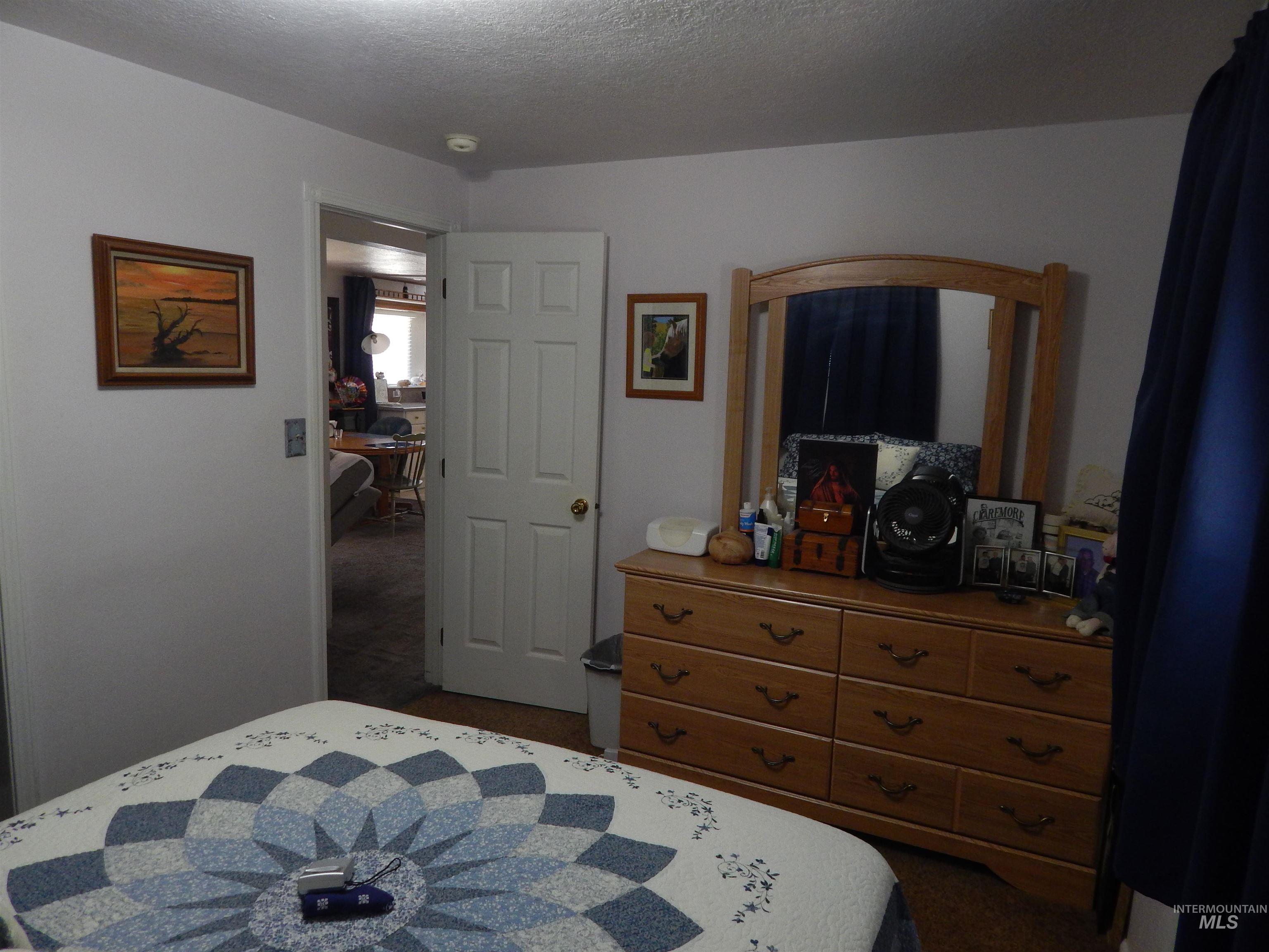 Bedroom featuring a textured ceiling and dark colored carpet