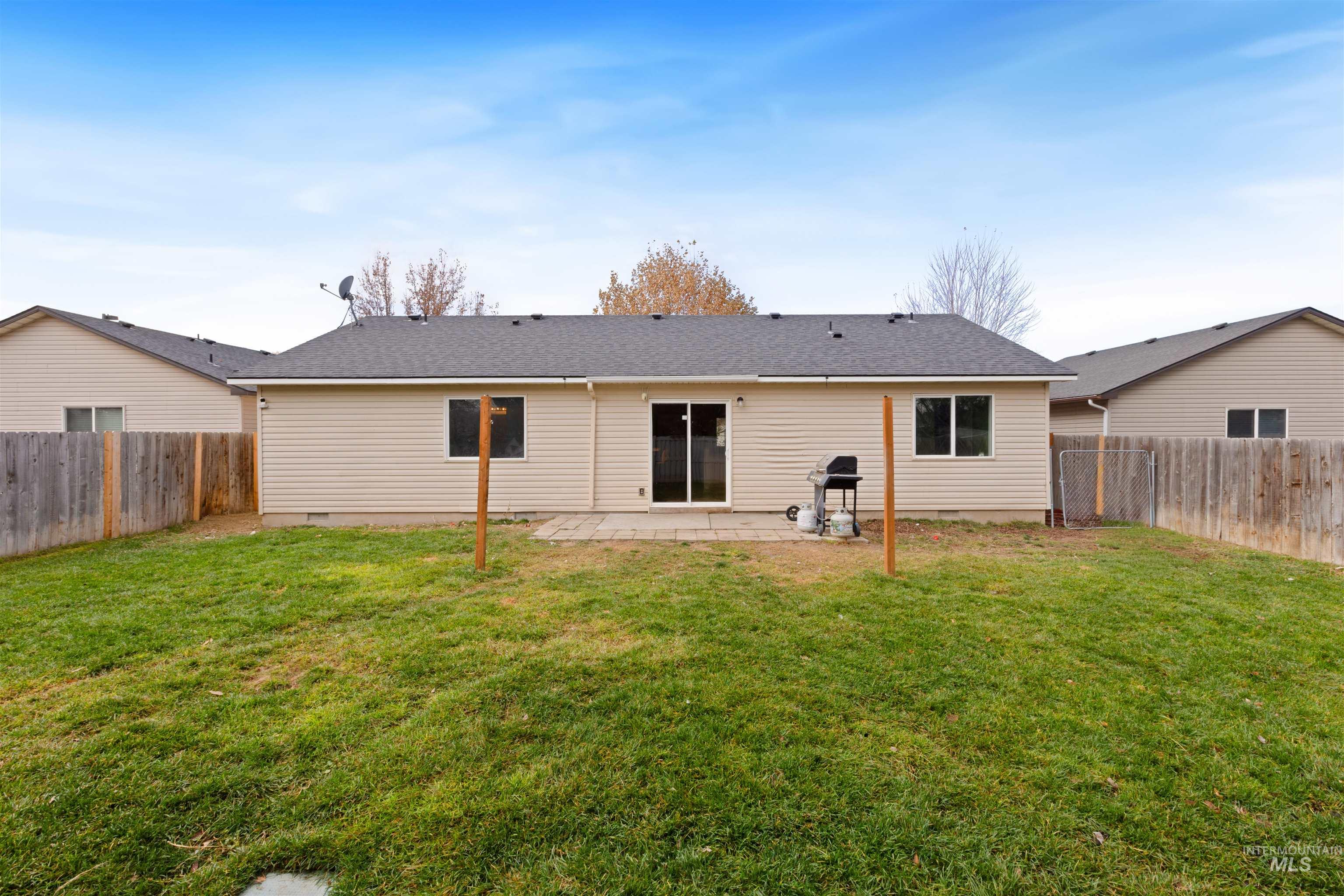 Rear view of property featuring a fenced backyard, a patio area, roof with shingles, and crawl space