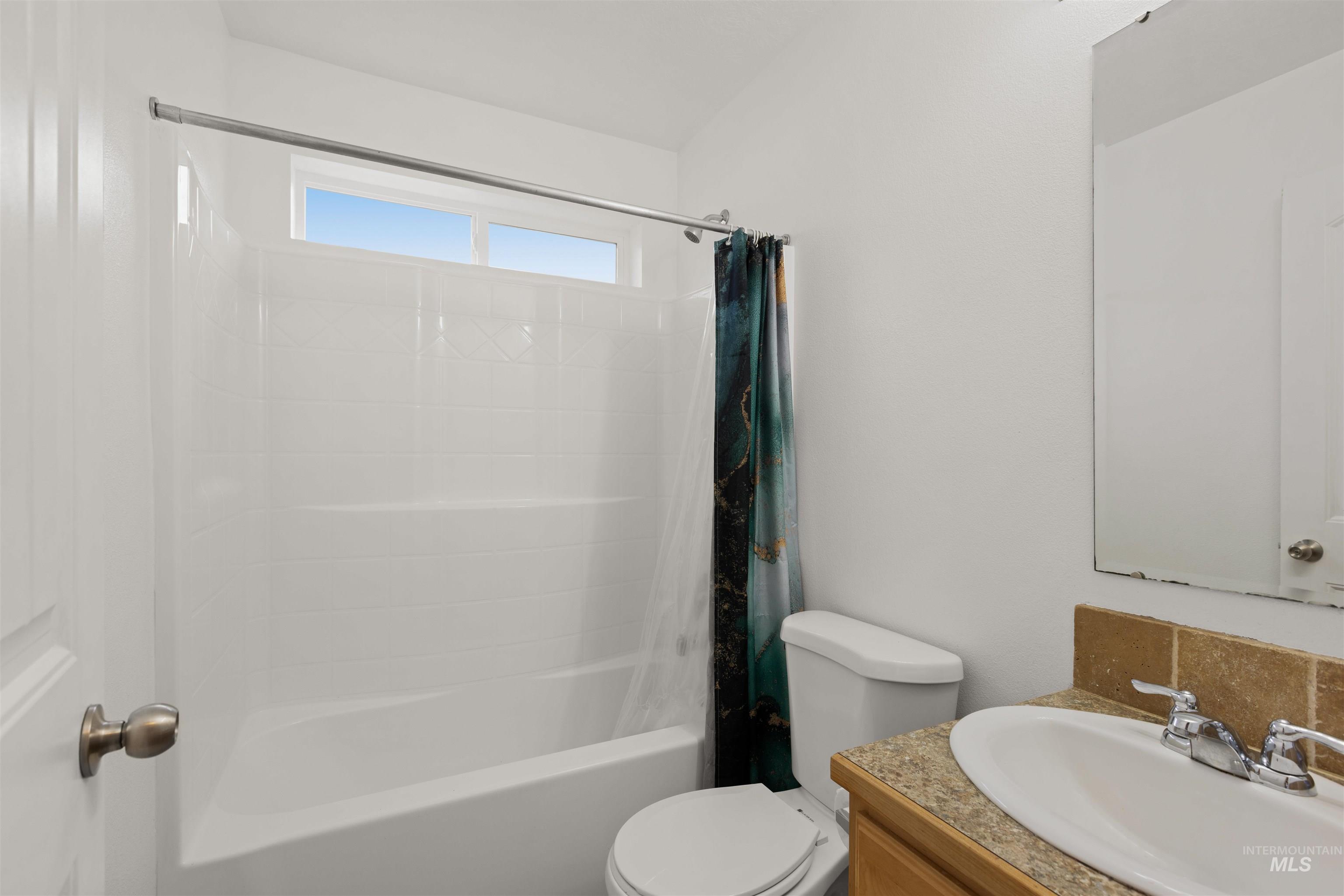Bathroom with shower / bathtub combination with curtain and vanity
