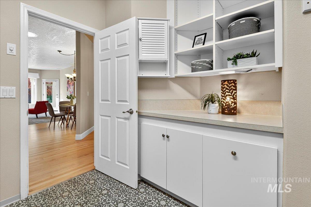 Corridor featuring a textured ceiling and a chandelier