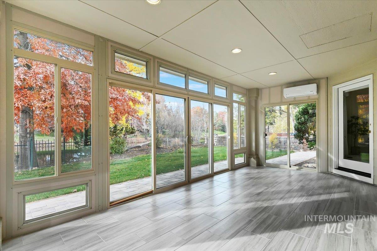 Unfurnished sunroom featuring recessed lighting and a wall mounted AC
