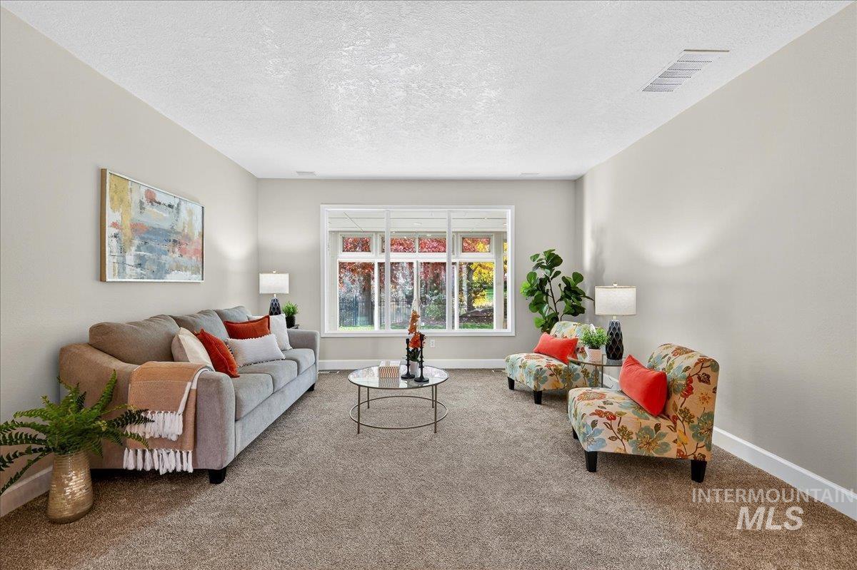 Living area featuring a textured ceiling and carpet