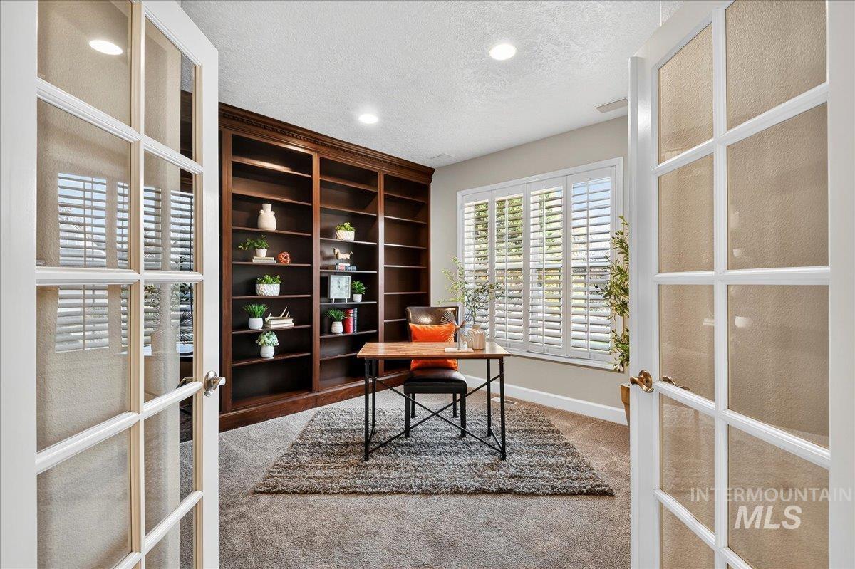 Office area with french doors, a textured ceiling, light carpet, and recessed lighting
