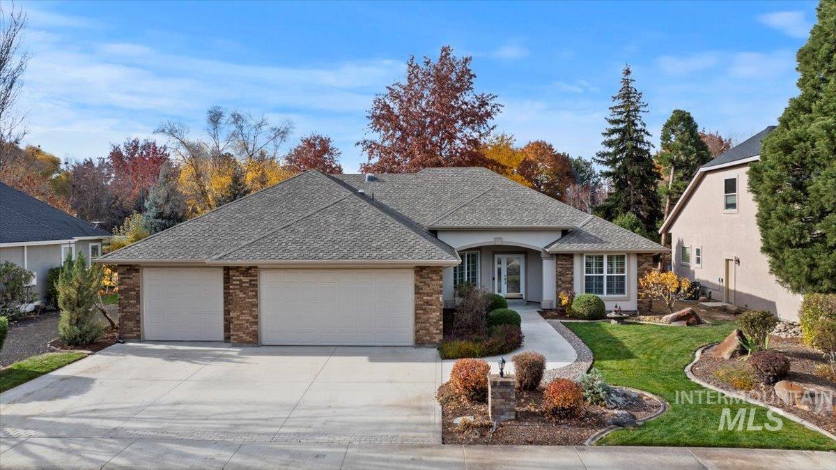 View of front of house with roof with shingles, a front lawn, a garage, concrete driveway, and brick siding