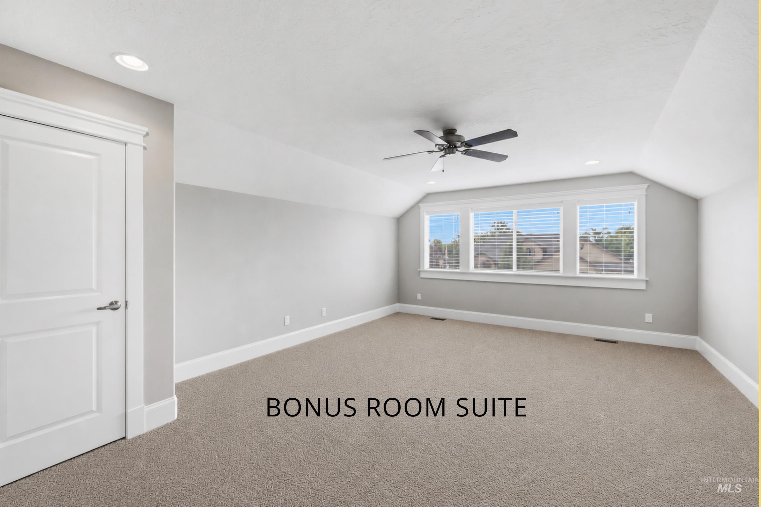 Attic room featuring a sloped ceiling, recessed lighting, a ceiling fan, a series of three windows with blinds, and neutral carpeting
