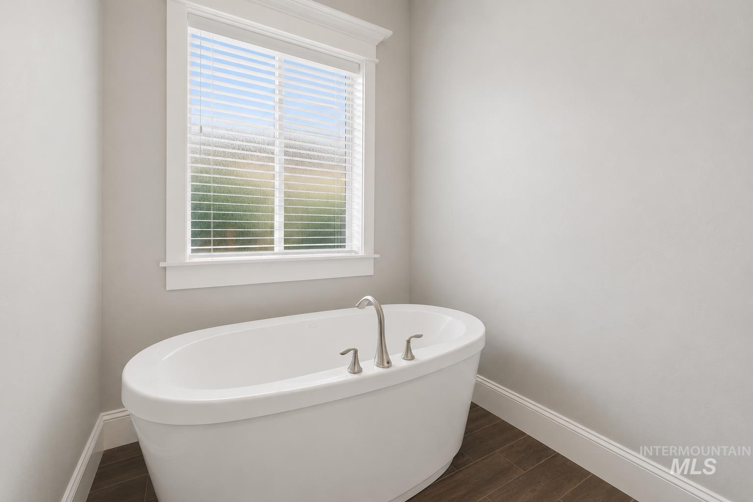 Freestanding oval bathtub with brushed nickel fixtures