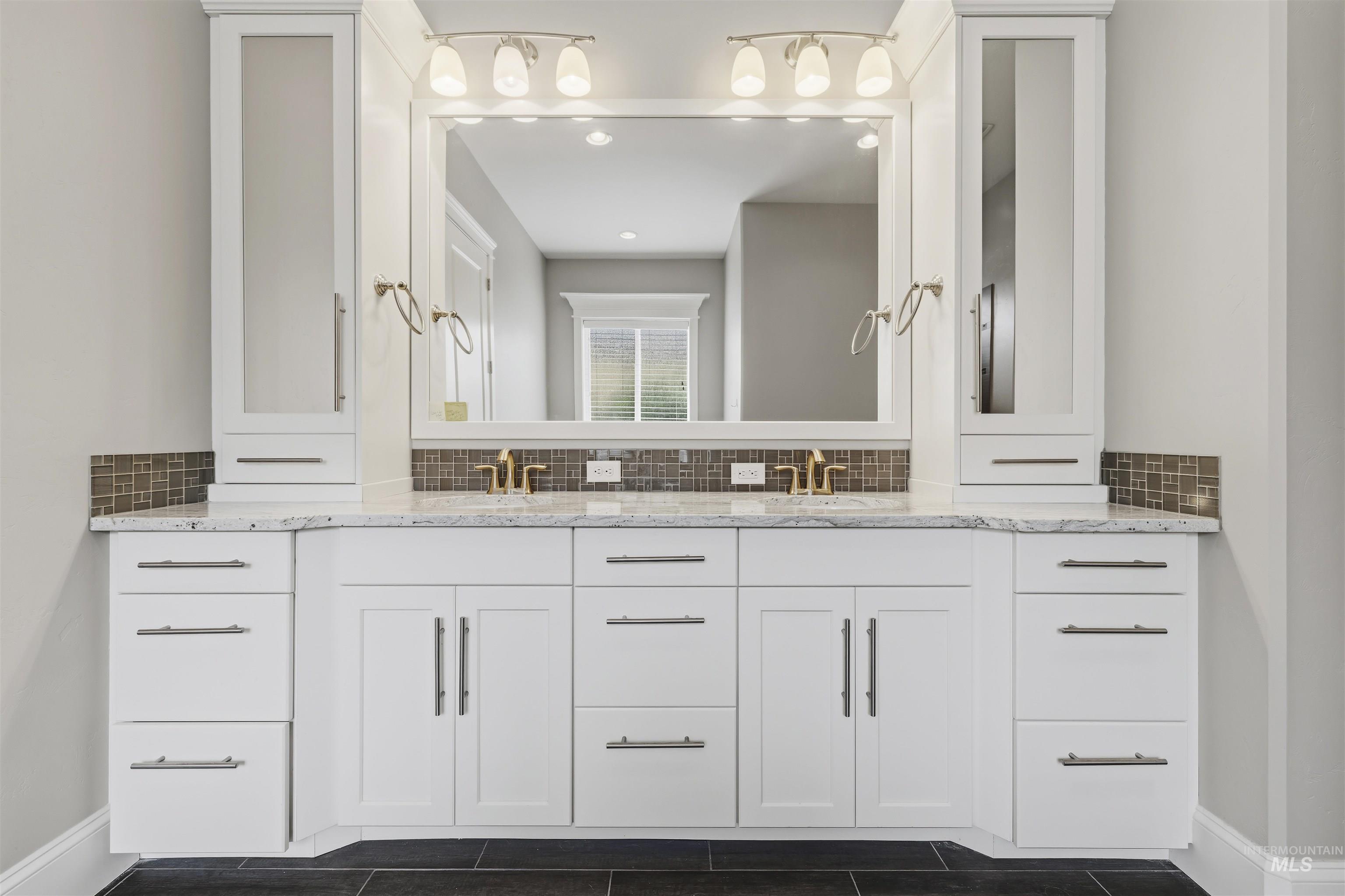 Dual vanity with white cabinetry and granite-style countertop