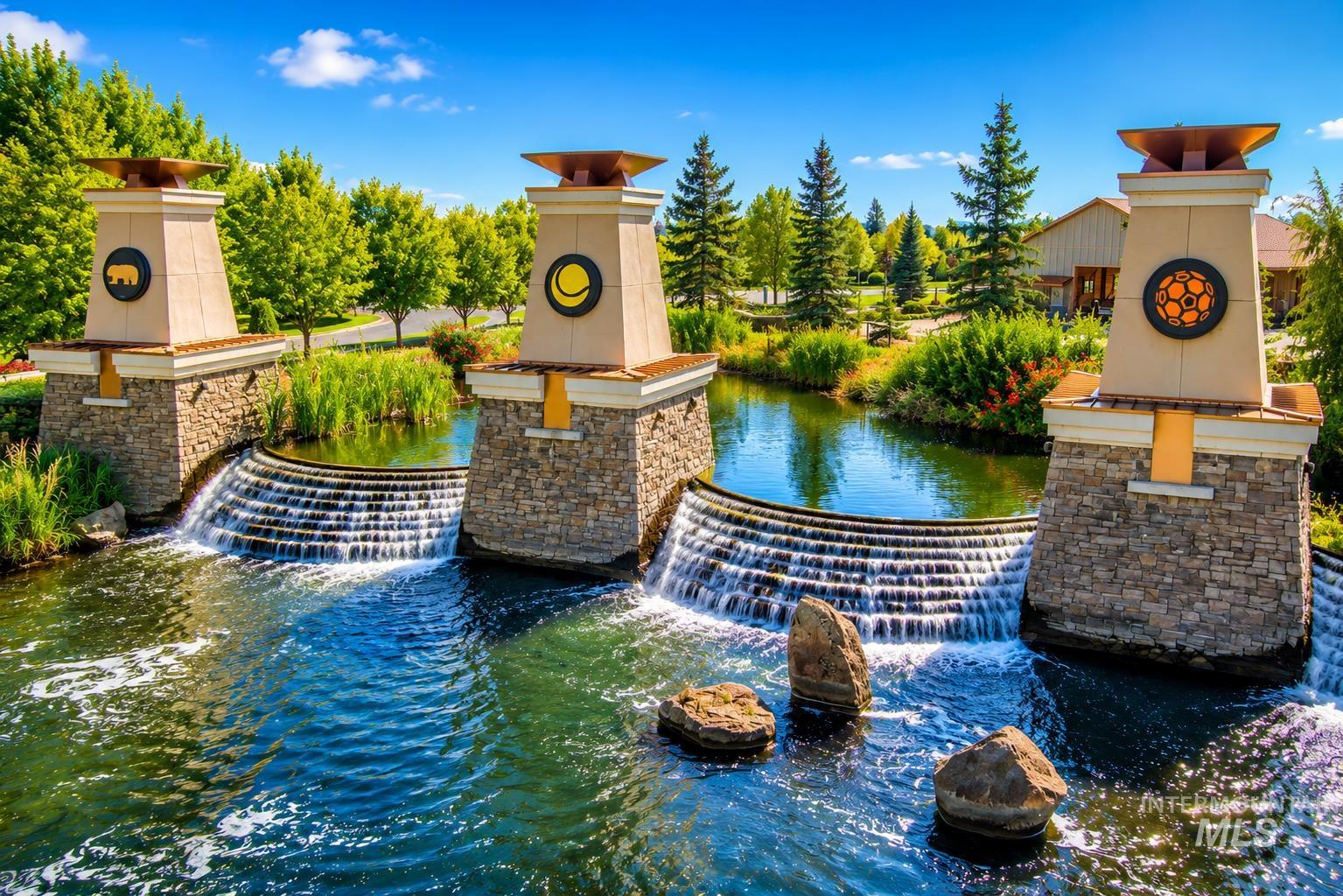 Stone-clad towers with decorative medallions and tiered water features create a distinctive entrance