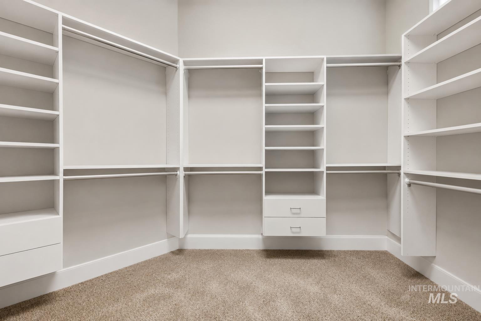 Custom closet system featuring white shelving, hanging rods, and integrated drawers