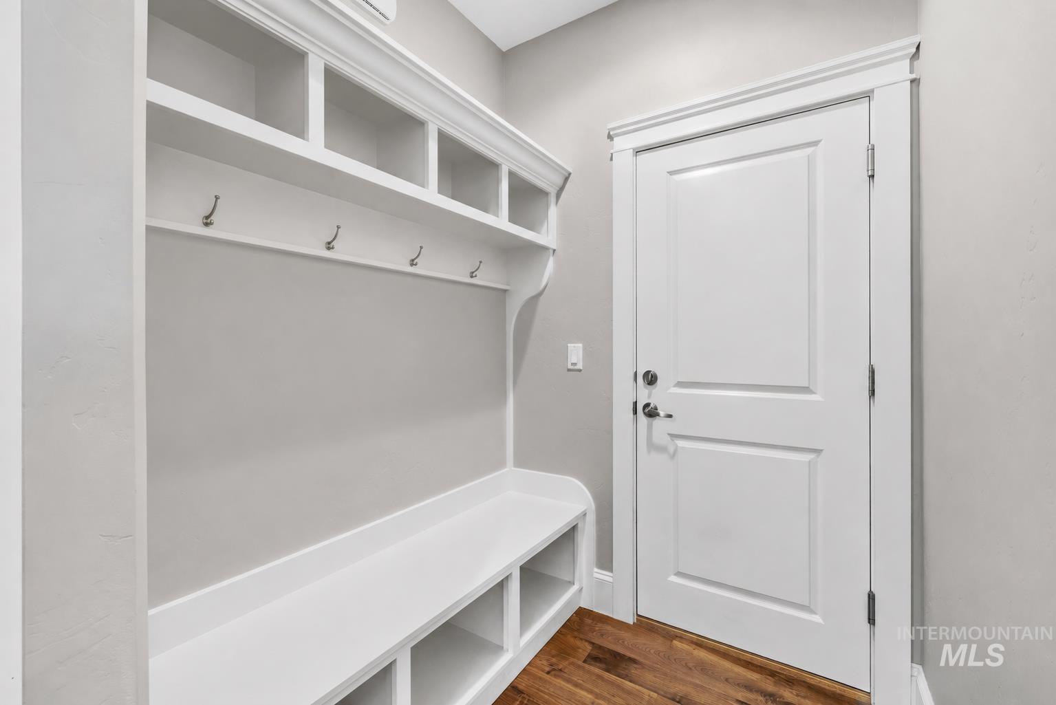 Built-in mudroom bench with cubby storage, upper shelving, and coat hooks