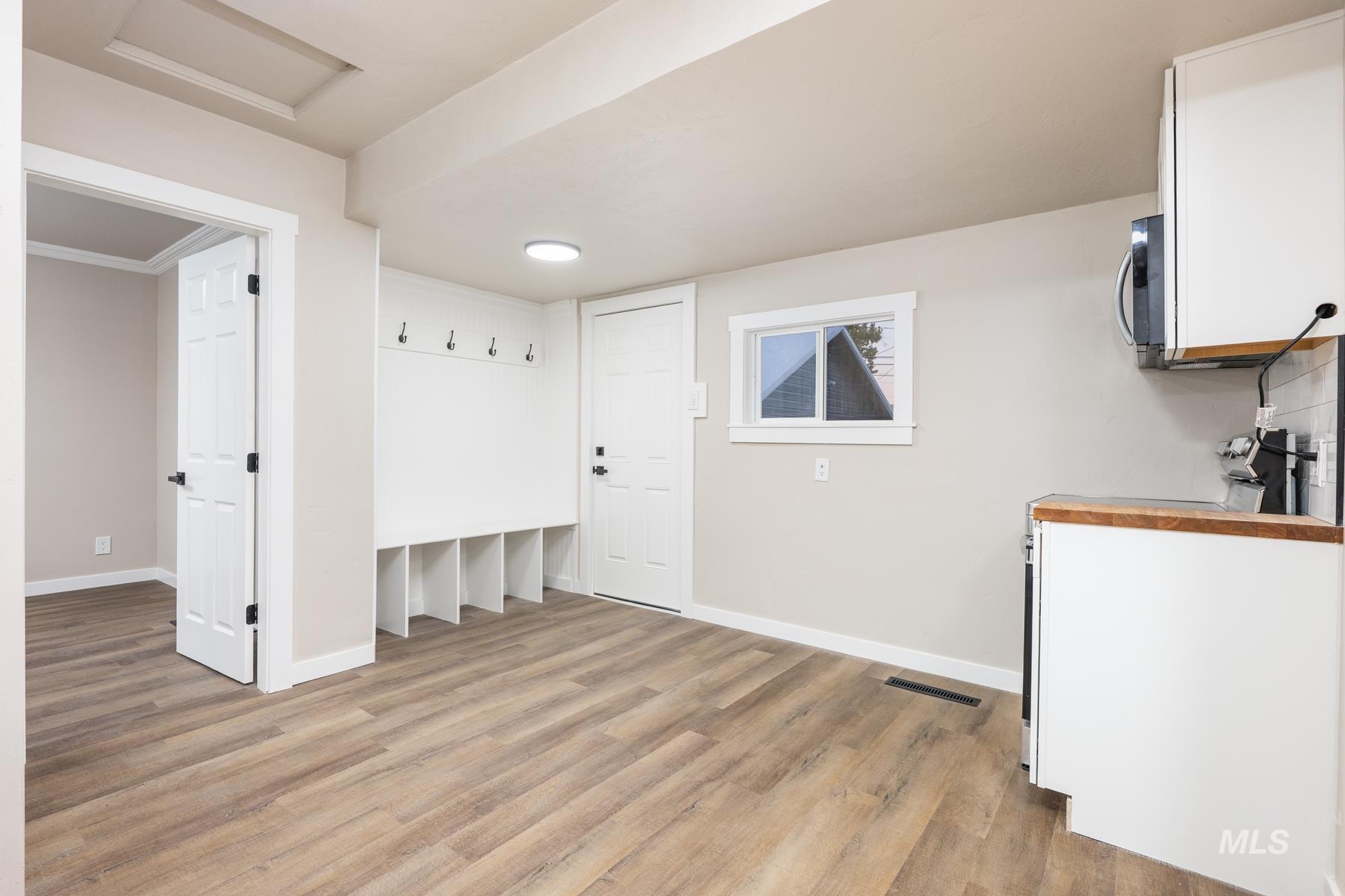 Mudroom featuring light wood finished floors and attic access