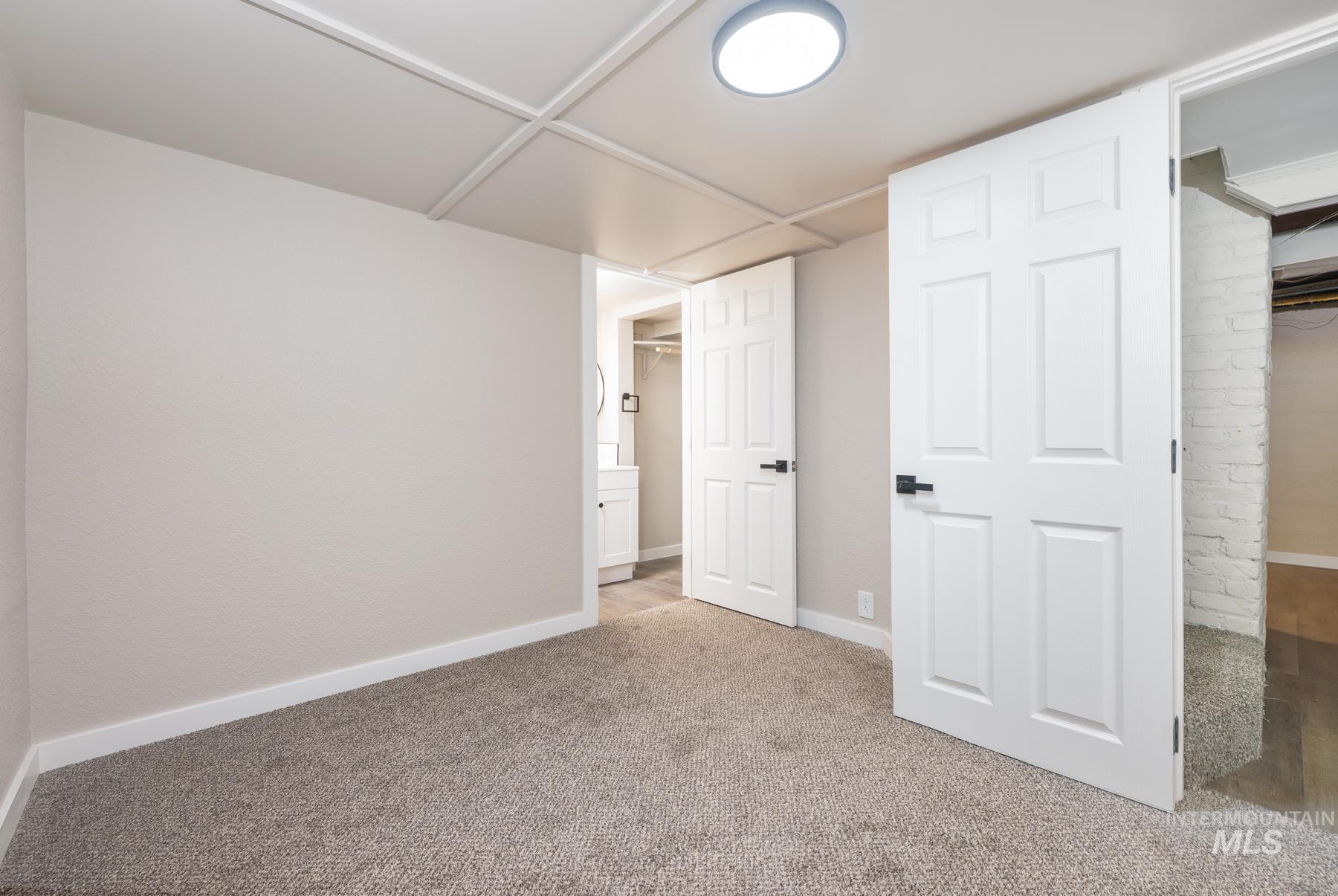 Unfurnished bedroom featuring a walk in closet and carpet floors